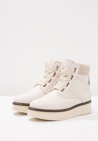 Jasne beżowe botki za kostkę wykonane z gładkiej skóry, z teksturowaną podstawą platformy, z przodem na sznurowanie i wyściełanym kołnierzem.