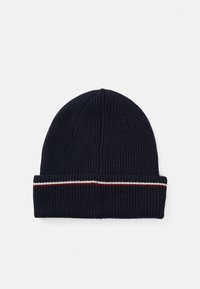 Marinblå stickad mössa med uppvikt kant, prydd med ett röd och vitt randigt accent. Ribbad textur genom hela, cylindrisk form.