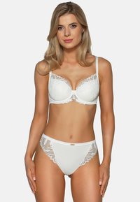 Reggiseno bianco in pizzo con coppe imbottite, bordi scallop e spalline regolabili, abbinato a pantaloni in pizzo bianco con fascia coordinata.