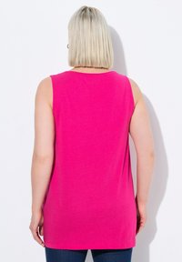 Top senza maniche rosa, realizzato in tessuto morbido, presenta un collo rotondo e una lunghezza che arriva fino ai fianchi, con un design semplice.