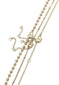 Kuldmetallist ketti, mis sisaldab vahelduvaid ümmarguseid helmeid ja lingid, mitmete kinnitustega ning erinevate tekstuuridega. Üldine sale disain.