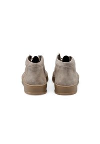 Bottines en suede gris clair avec une surface texturée, un bout arrondi et une semelle en caoutchouc marron clair. Elles possèdent un dos haut et des zips.
