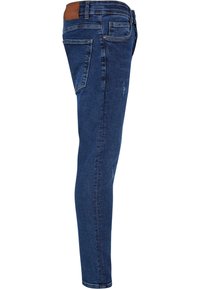 Tanke jeans v temno modri barvi z rahlimi poškodbami. Imajo rjavo usnjeno značko na pasu in tradicionalno zasnovo s petimi žepi.