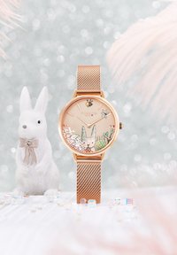 Złoty zegarek w kolorze różowego złota z siateczkowym paskiem, z tarczą inspirowaną naturą, na której znajdują się królik, pszczoła oraz błyszczące akcenty. Miękka tekstura i zabawny design.