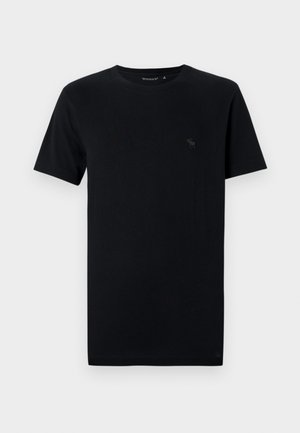 Camiseta de algodón negra con mangas cortas, cuello redondo, que presenta un pequeño y sutil logo en un tono a juego en el área del pecho izquierdo.