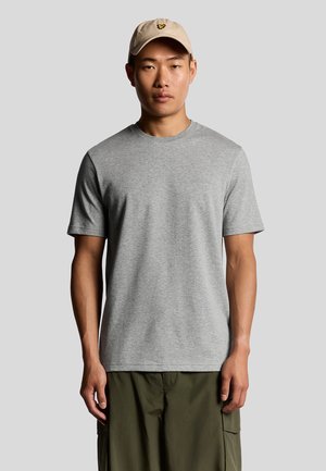 Grijs T-shirt met korte mouwen van katoen, ronde halslijn, met een minimale merkuiting. Gecombineerd met olijfgroene cargoshorts en een beige pet.