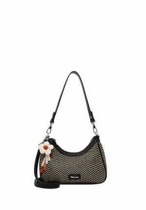 Kleine handtas met zwart-beige zigzagpatroon, zwarte bandjes en een bloemvormige sleutelhanger aan de zijkant.