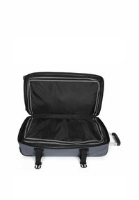 Valise à roulettes avec un extérieur rigide bicolore, fermeture éclair et intérieur noir. Comprend une poche en mesh et des sangles de compression doubles.