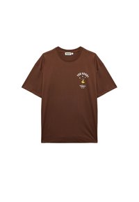 Camiseta de algodón marrón con manga corta. Presenta el texto "¿TE ENCUENTRAS BIEN?" y un diseño gráfico. Cuello redondo y ajuste relajado.