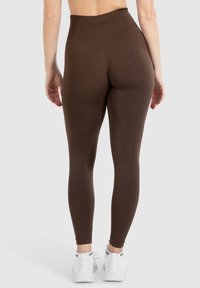 Hoge taille bruine leggings met een naadloos ontwerp, gemaakt van rekbare stof, met een gladde textuur en een aansluitende silhouet.