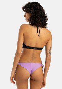 Black bikini top with adjustable neck and back straps, paired with purple tie-side bikini bottoms, smooth texture, minimalistic design.
