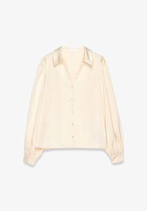 Krémová hodvábna blúzka s výstrihom do V, predným zapínaním na gombíky a nadýchanými rukávmi. Má hladký povrch a manžety na zápästiach.