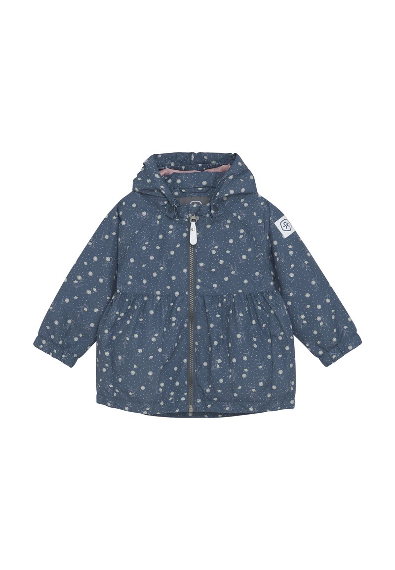 Blå jacka med samlad midja, huva och framdragkedja. Har ett vitt blommönster och ett logotyp-märke på vänster ärm.