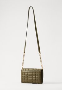 Borsa a tracolla trapuntata verde oliva con catena e tracolla in pelle dorate. Forma rettangolare con superficie testurizzata e design strutturato.