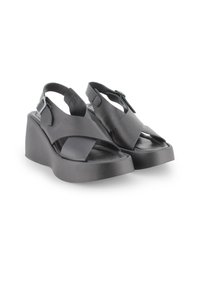 Sandalias de cuña negras con un diseño de tiras cruzadas, punta abierta, correa ajustable en el tobillo, fabricadas en material de cuero suave.