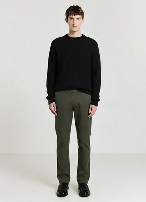 Maglione nero a coste, pantaloni verde oliva, scarpe nere, design semplice, materiale texturizzato, vestibilità comoda, in piedi contro uno sfondo neutro.