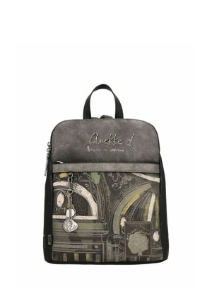 Small backpack with abstract architectural patterns in green, gray, and beige tones, front zipper pocket, and decorative metal keychain.