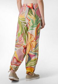 Färgglada, mönstrade joggarbyxor med blommönster i rosa, grön och gul. Tillverkade av lätt material med en elastisk ankle cuff.
