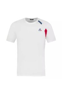 Camiseta blanca de manga corta, con acentos azules y rojos en los hombros, y un logo en el pecho. Fabricada con un tejido ligero.