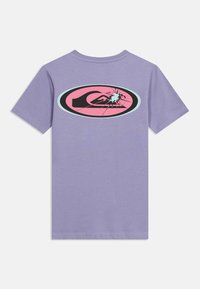 Μωβ κοντομάνικο μπλουζάκι με κεντρικό οβάλ σχέδιο που απεικονίζει ένα στυλιζαρισμένο μαύρο κύμα και ένα εφέ σπασμένου γυαλιού μπλε σε ροζ φόντο.