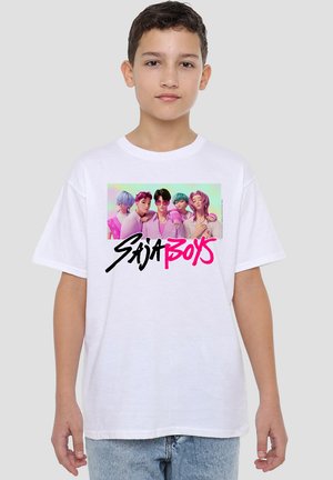 Young person wearing white T-shirt with colorful anime-style characters and "Saja Boys" text in black and pink on the front.