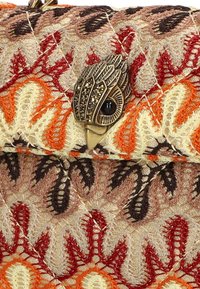 Borsa a pochette ricamata con motivi intricati in crema, arancione e rosso. Presenta una chiusura decorativa a forma di uccello in metallo sulla parte superiore.