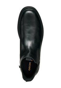 Bottine cheville en cuir noir avec une finition brillante, panneaux latéraux élastiques, forme épurée et une languette de tirage. L'intérieur arbore le nom de la marque "GEOX."