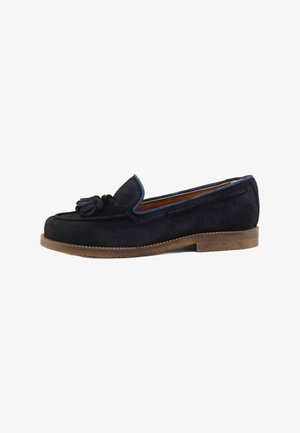 Mocasín azul marino de ante para hombre con borlas, suela marrón y tacón bajo.