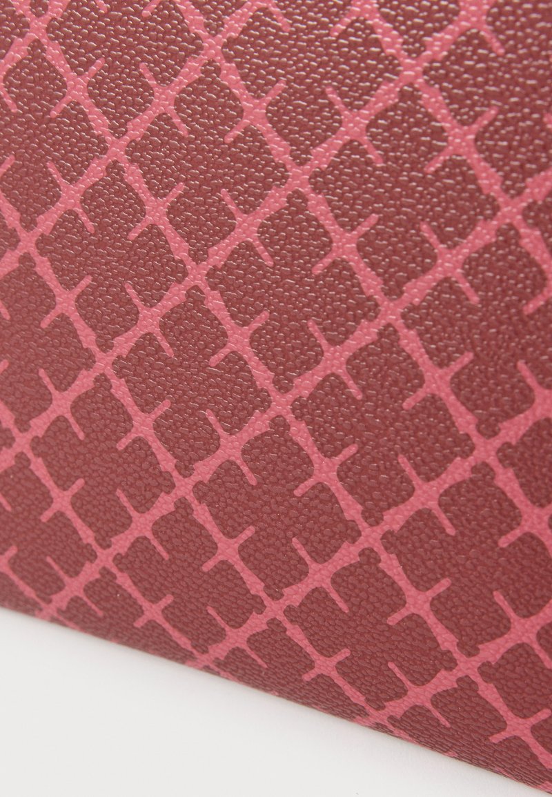 Burgunderfarbenes strukturiertes Material mit einem erhabenen Rautenmuster in Rosa. Die Oberfläche ist glatt mit einem dezenten Glanz, der visuelle Tiefe erzeugt.