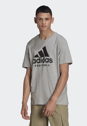 Grijze katoenen t-shirt met een ronde hals, voorzien van een groot zwart Adidas-logo en de tekst "Voetbal" afgedrukt op de voorkant.