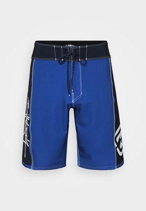 Blue board shorts made of stretch fabric, featuring a black waistband, drawstring, white stitching, and a logo print on the side.