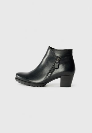 Black ankle boot with a sleek design, featuring a side zipper and a modest heel, resting against a plain white background.