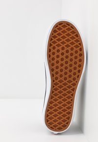 Semelle de chaussure pour homme, avec une semelle en caoutchouc marron à motifs et un bord blanc. Le design comprend une texture en grille pour l'adhérence.
