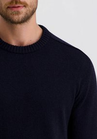 Marineblauer Strickpullover mit einem gerippten Rundhalsausschnitt und strukturiertem Stoff. Verfügt über eine klassische Passform und keine sichtbaren Hardwareelemente oder Muster.