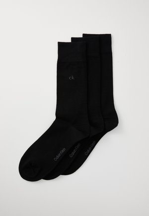 Schwarze Baumwollsocken im Dreierpack. Mit gerippten Bündchen und einem kleinen "ck"-Logo auf jeder Socke. Glatte Textur mit klassischem Design.