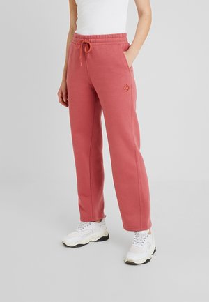 Roze joggingsbroek van zachte stof met een relaxte pasvorm, een elastische tailleband met trekkoord, zijzakken en een logo-detail op de linker bovenbeen.