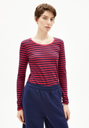 Langärmliges T-Shirt in rot und marineblauen horizontalen Streifen, mit Rundhalsausschnitt und tailliertem Design, kombiniert mit marineblauen Hosen.