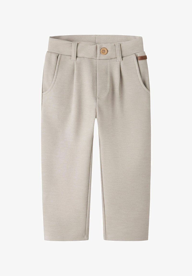 Pantalon en tissu beige clair texturé avec passants de ceinture, bouton avant, poches latérales et une petite étiquette de marque en cuir marron sur la ceinture.