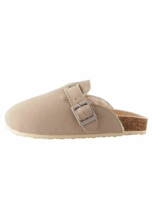 Beige mokassin klomp van suede met een zilveren gesp, kurken voetbed en een gestructureerde rubberen zool. Gladde afwerking met gestikte accenten.