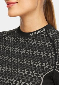 Czarny koszulka sportowa z geometrycznym wzorem kwiatowym, z okrągłym dekoltem i logotypem na kołnierzyku. Gładki materiał.