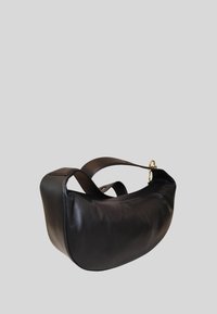 Sac à main en cuir noir avec une forme courbée et douce. Dispose d'une large bandoulière et d'accents en métal doré. Texture lisse, sans motifs visibles.