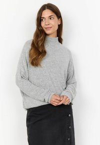 Grey, textured sweater with a high neckline and loose fit, paired with a black, knee-length skirt featuring button details on one side.