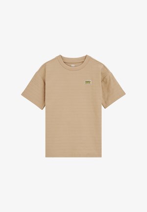 Tricou bej cu mâneci scurte, cu nervuri, guler rotund și o mică etichetă dreptunghiulară „Puerto Montana” pe pieptul stâng.