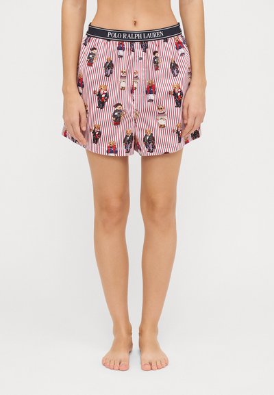 Boxer en coton avec des rayures verticales rouges et blanches, ornés de diverses illustrations de chiens. Taille élastique avec le logo "POLO RALPH LAUREN".
