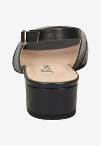 Schwarze High Heels Sandalen mit glänzendem Lederfinish, offenem Rücken, verstellbarem Riemen und gepolsterter Innensohle. Robuste schwarze Plattformbasis.