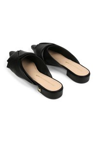 Svarta skinnslip-ons med spetsiga tår, en vriden överlappningsdesign och en låg klack. Innersulan är nude och har en detalj med guldlogotyp.