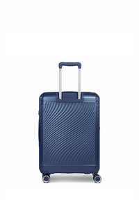 Maleta rígida de color azul oscuro con textura ondulada, mango retráctil de aluminio y cuatro ruedas multidireccionales.