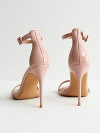 Sandalias de tacón alto de charol rosa con tira en el tobillo, punta abierta y tacón de aguja delgado. Textura suave y un diseño minimalista.