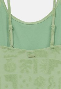 Groene badstof tanktop met een gestructureerd patroon van verschillende vormen en ontwerpen. Verstelbare bandjes en een klein zilveren "Roxy" label.