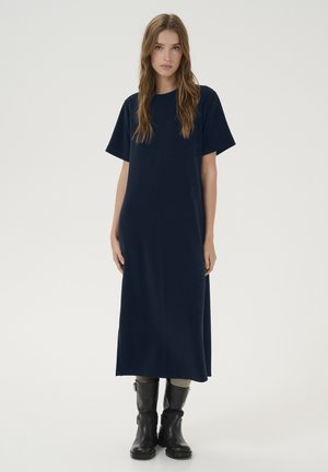 Navy blue, knee-length dress with short sleeves and relaxed fit, made of soft material. Worn with black knee-high boots. Simple design.